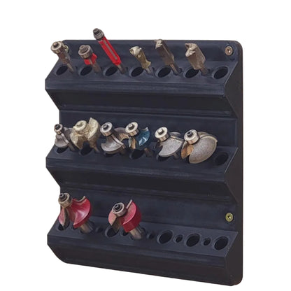 Black wall-mounted router bit holder with various bits on a white background