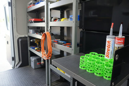 Green plastic components and two tubes of adhesive on a black surface